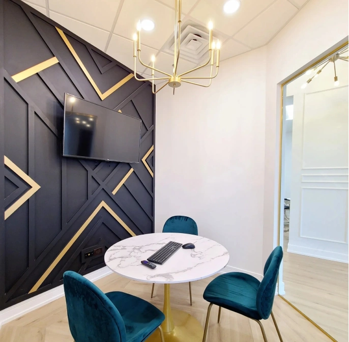 Modern dental office consultation room with elegant black and gold wall design at Seven Bridges Dental Studio