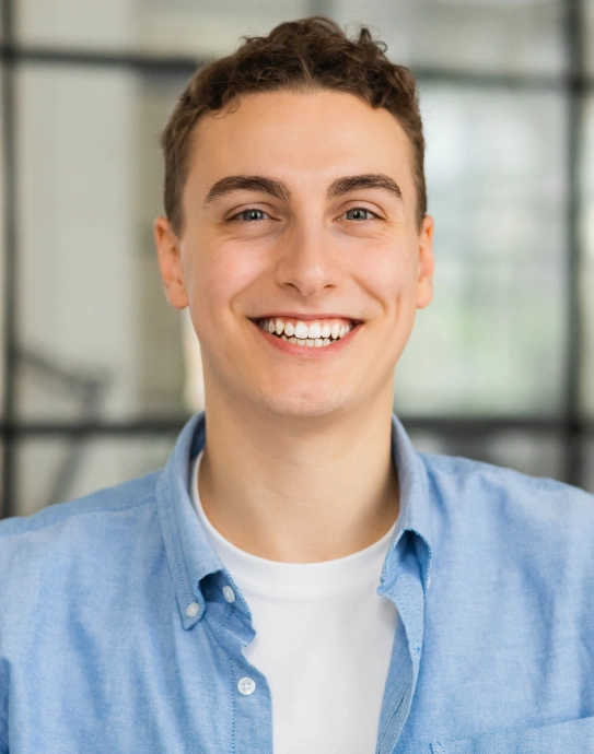 Young man smiling confidently with even gum line after gum recontouring treatment