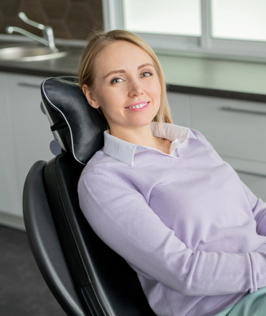 Female patient relaxing in dental chair before periodontal therapy treatment